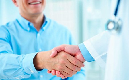 Врач жмет руку пациенту